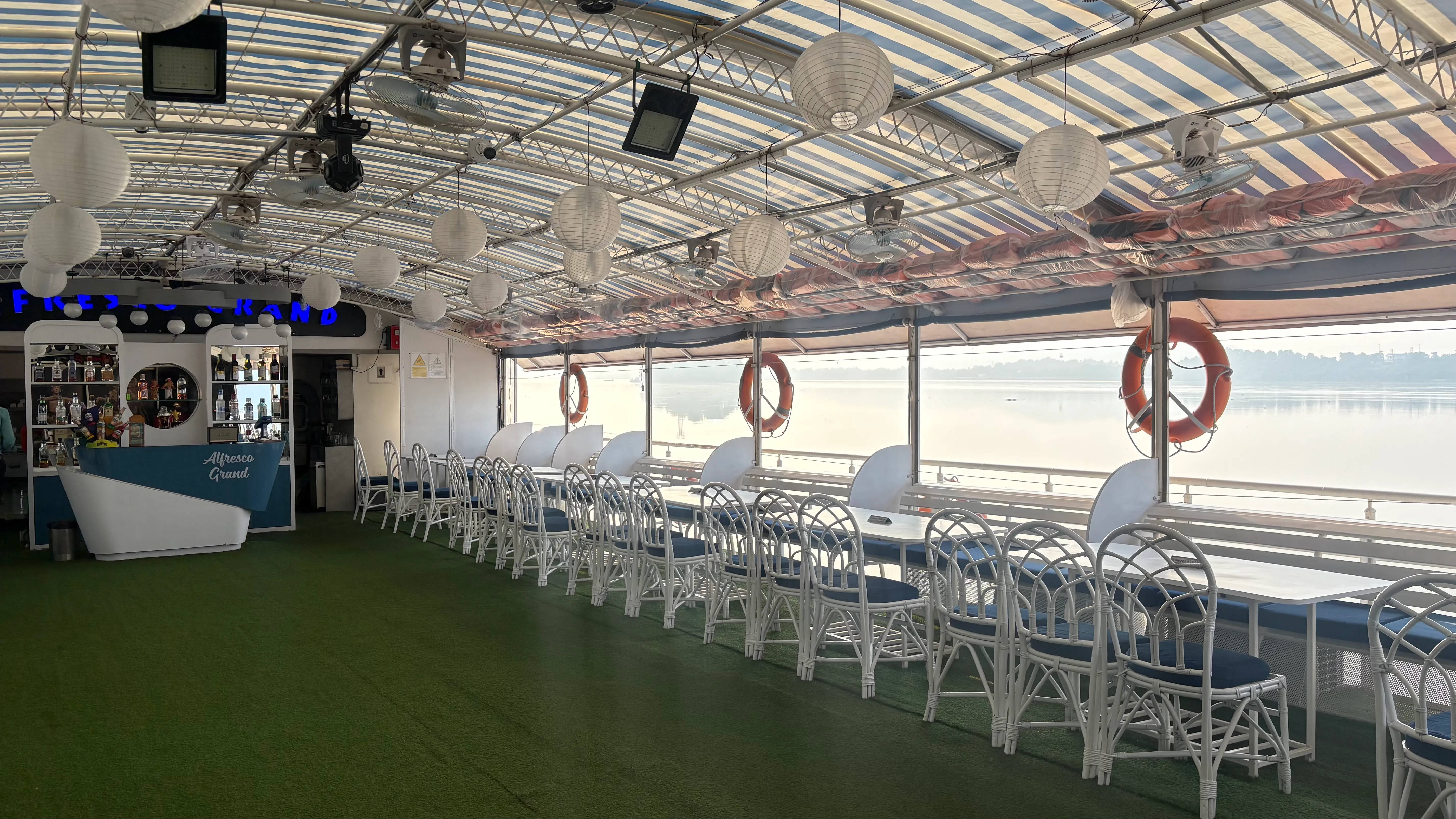Roofed middle deck of Alfresco Grand with bar and open river views