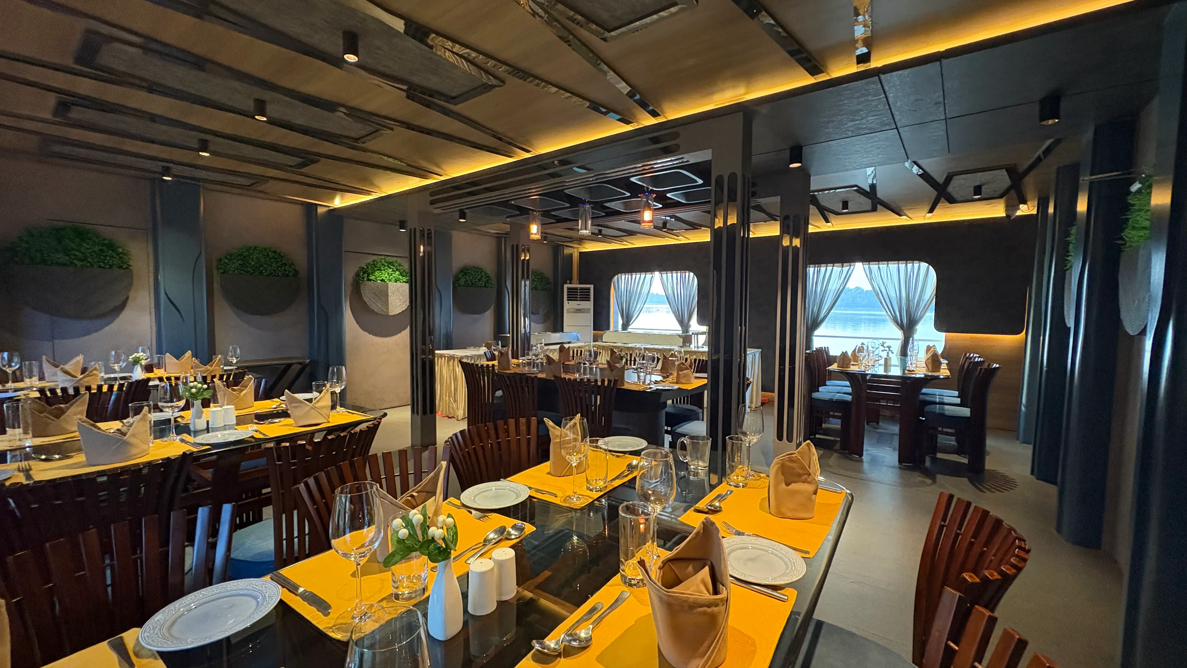 Dining hall of the Alfresco Grand dinner cruise with the river visible through the windows