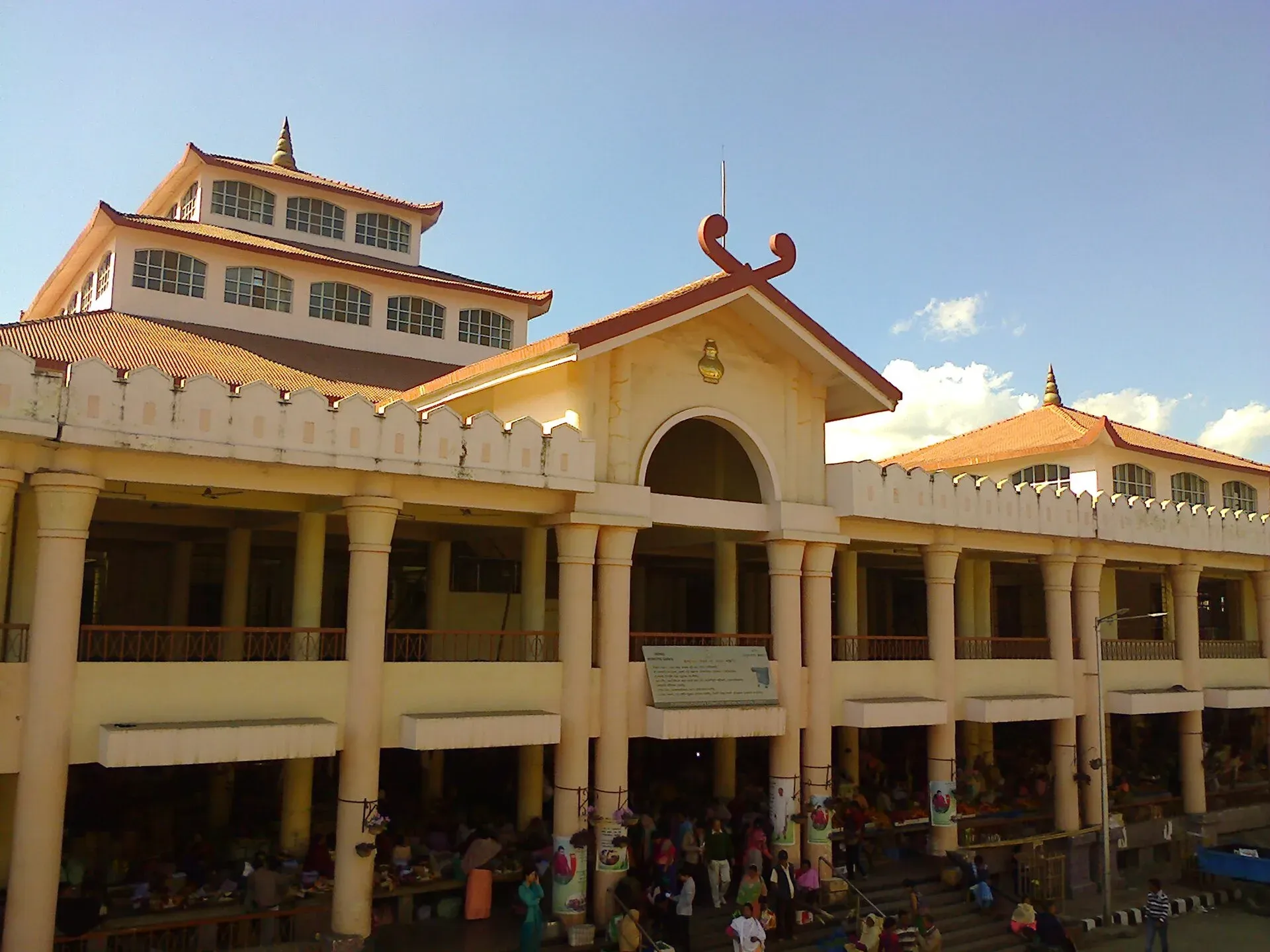 The pillared, pagoda-roofed facade of Ima Keithel in Imphal, women traders and shoppers filling the colonnaded market stalls at street level