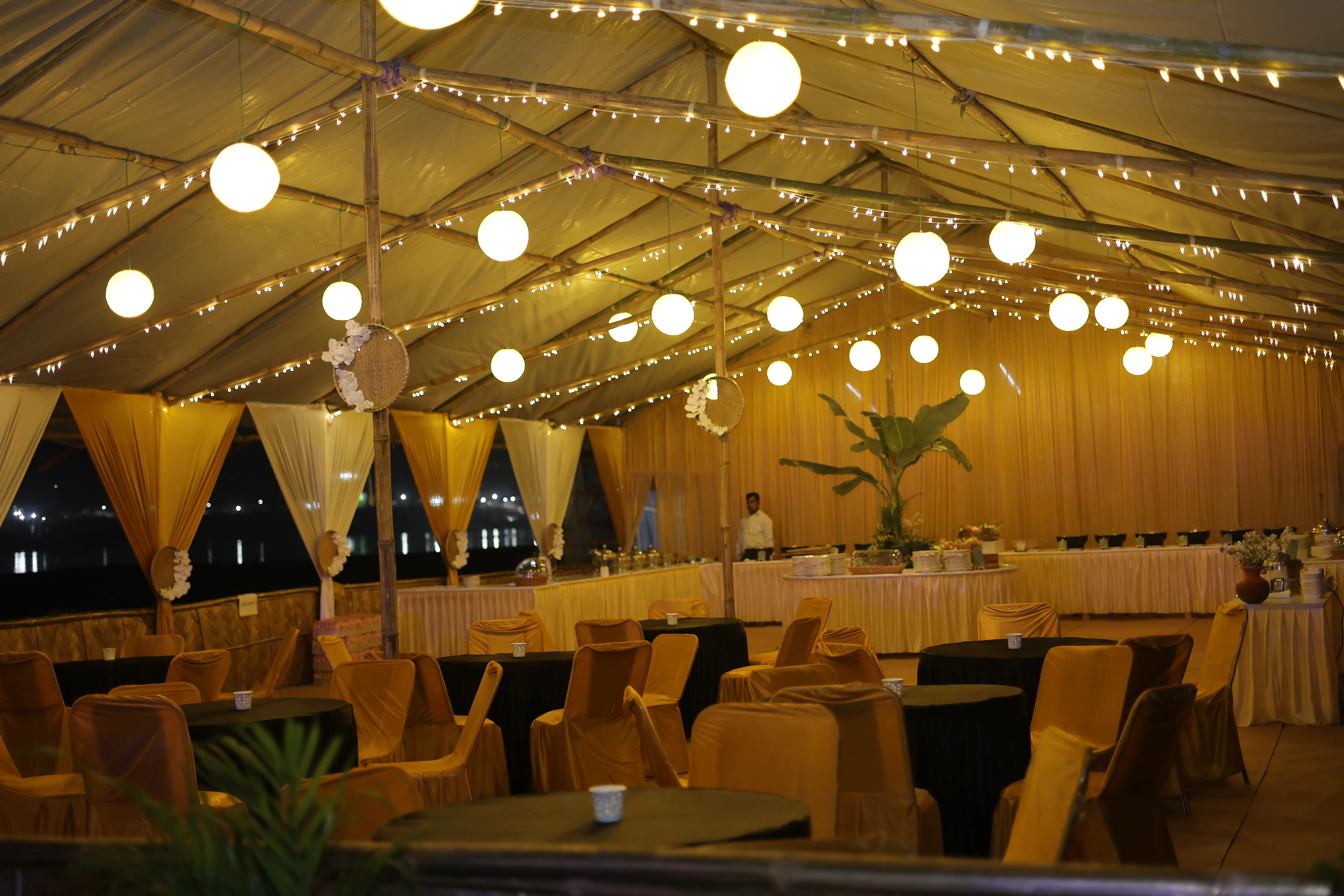 Golden-lit dining hall interior during a river island celebration
