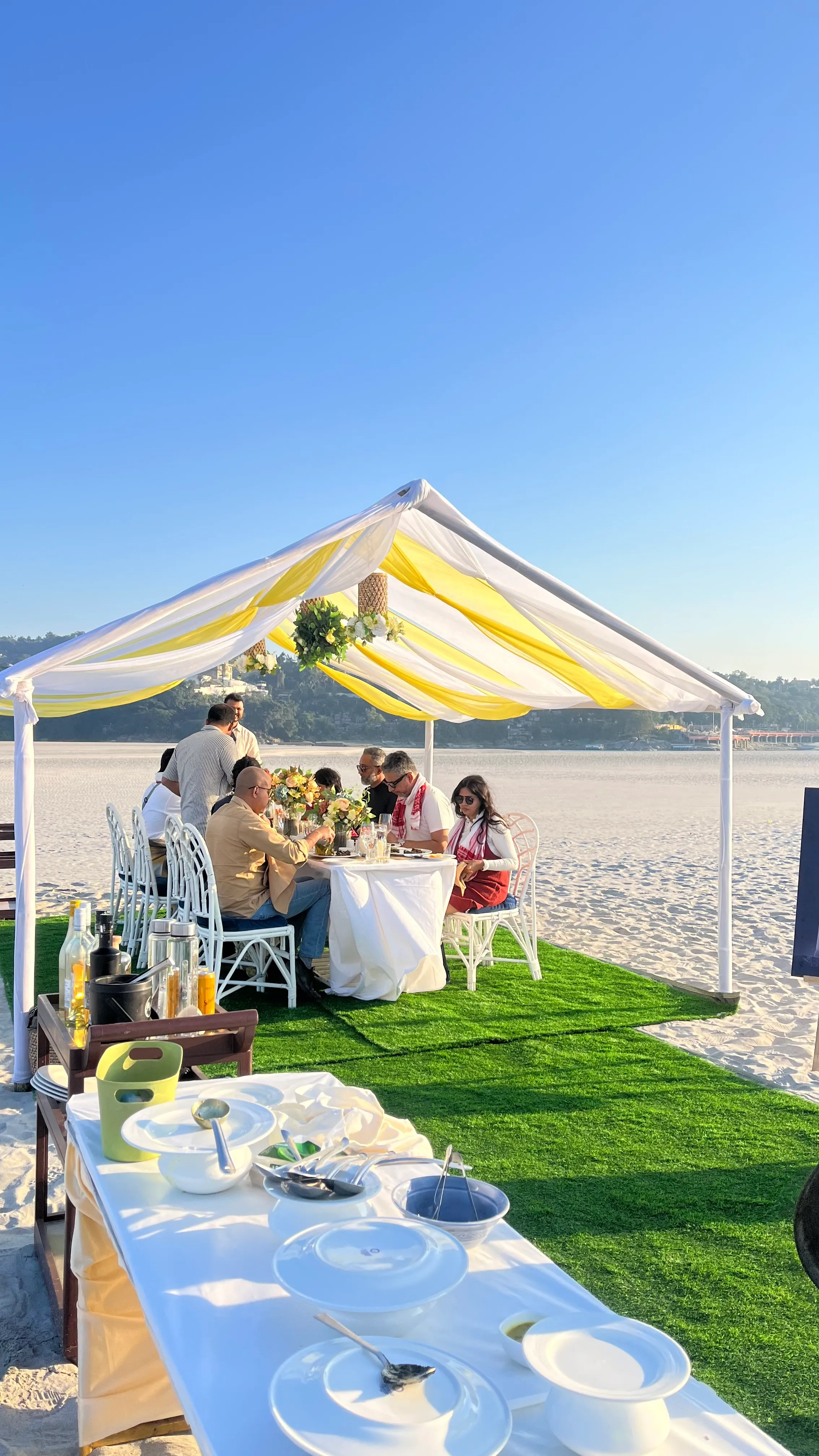Guests at a private lunch under a marquee on a white Brahmaputra sandbar