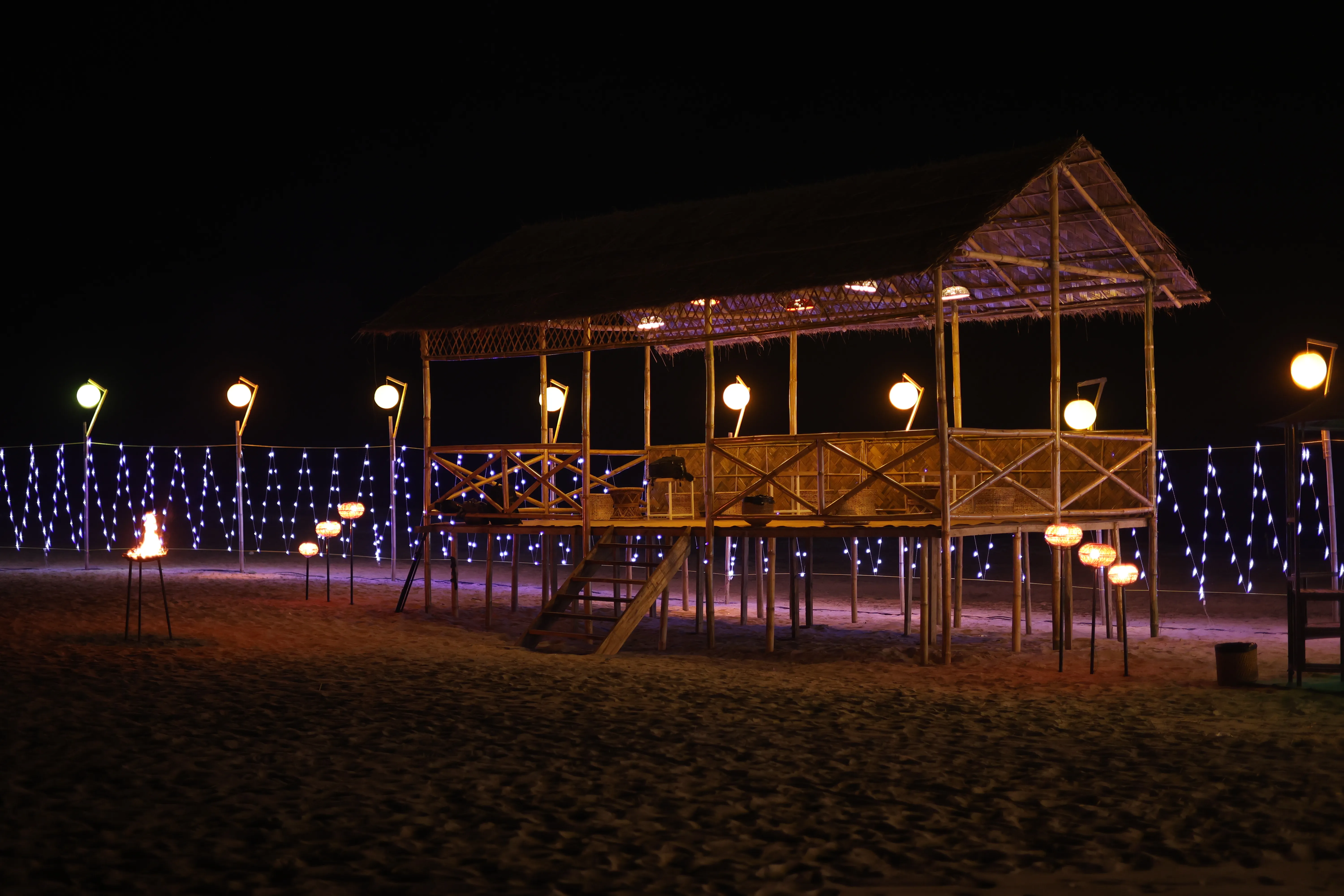 Stilt pavilion built on the sand for a river island event