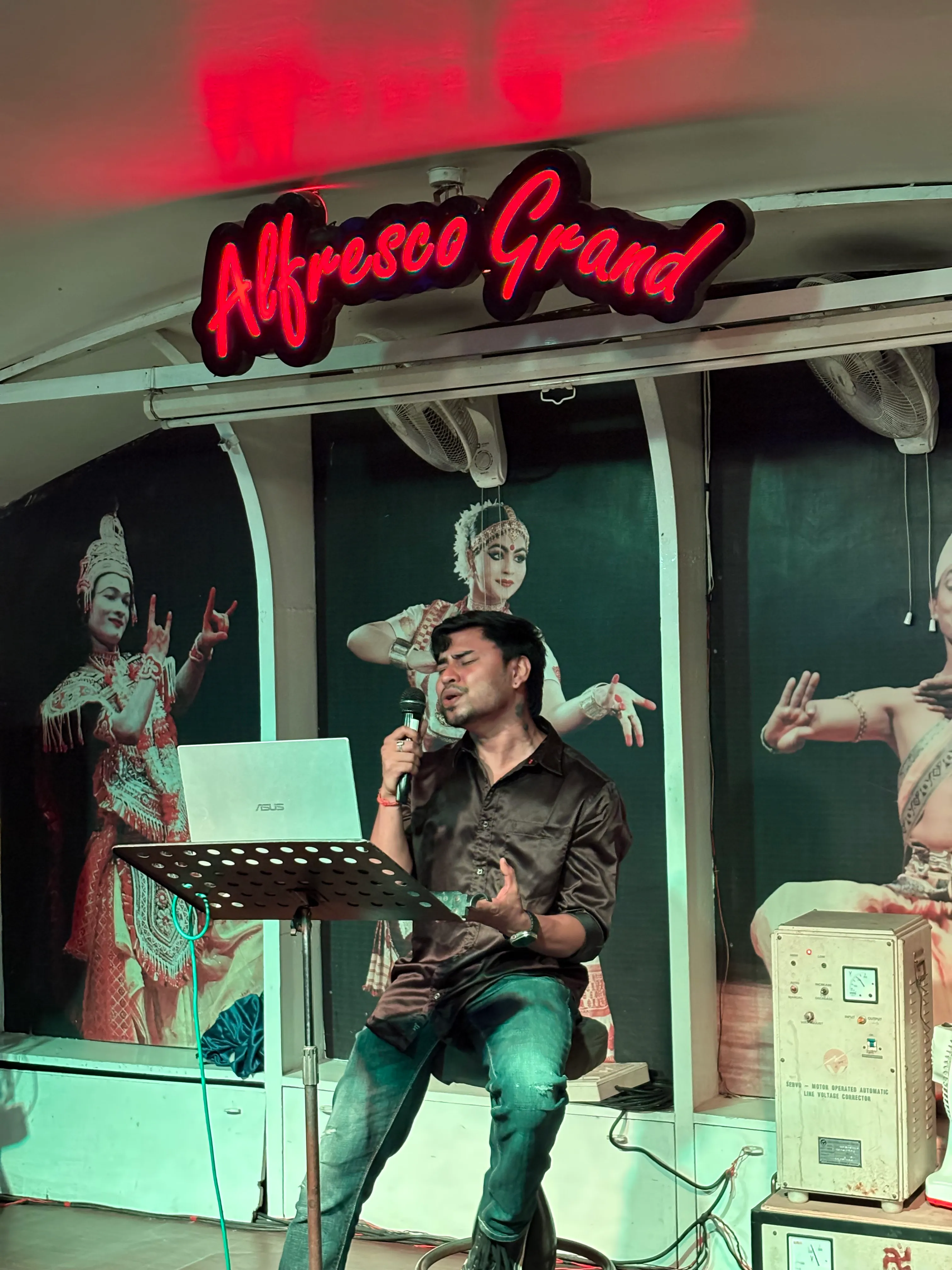 Live singer performing under the Alfresco Grand sign on the dinner cruise