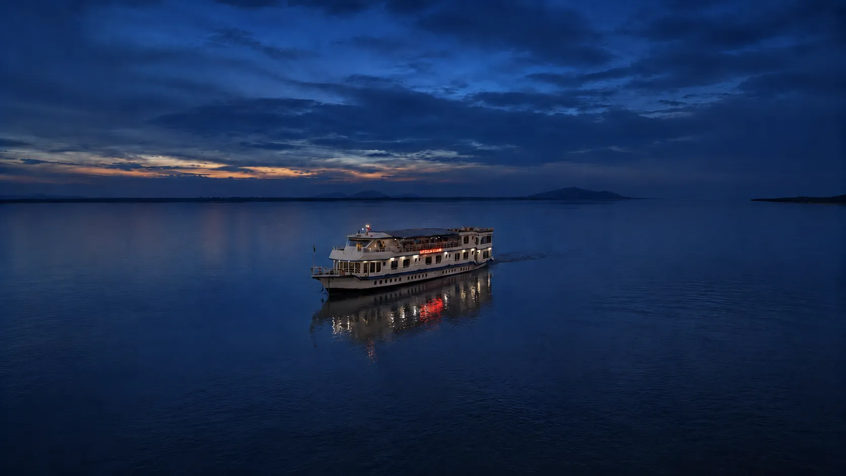 Alfresco Grand glowing on a deep blue Brahmaputra in the quiet hour after sunset